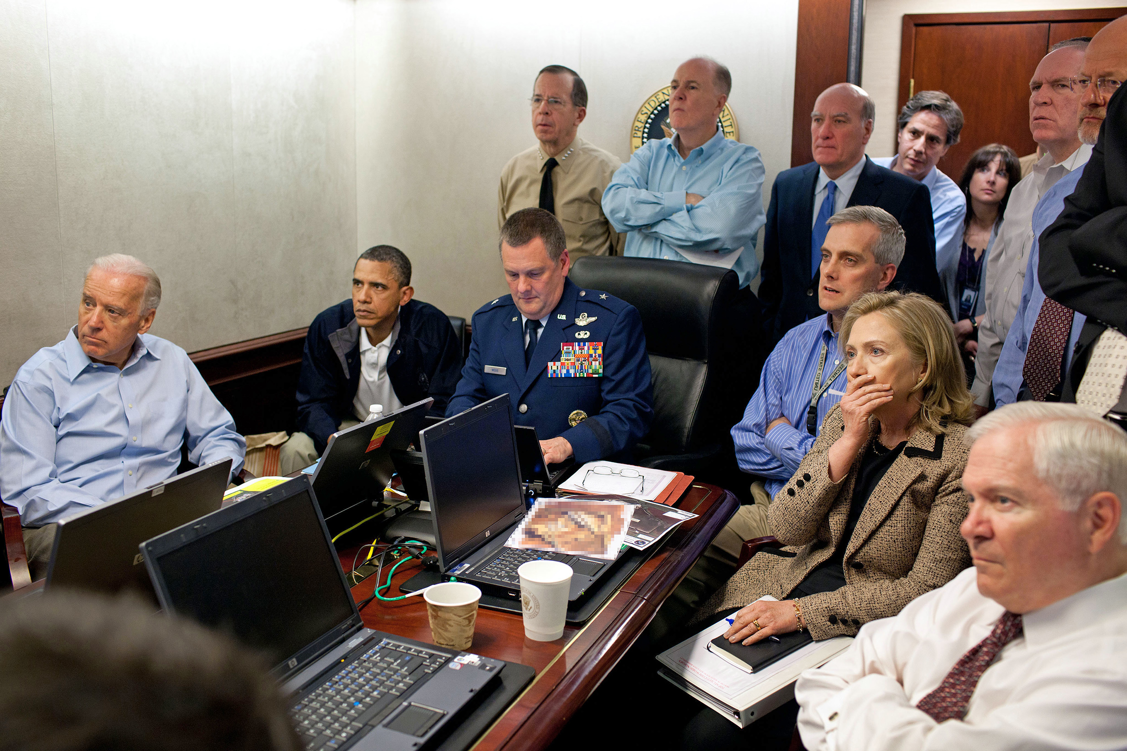 May 1, 2011: In the White House Situation Room, President Barack Obama and members of his national security team monitor the raid on Osama bin Laden's compound in Pakistan. He is joined by Vice President Joe Biden (seated, left) and Secretary of State Hillary Clinton and Defense Secretary Robert Gates (both seated, right). As they watch drone video of the compound, Admiral William McRaven gives them a live briefing by secure video link from a base in Jalalabad, Afghanistan. (White House photo)